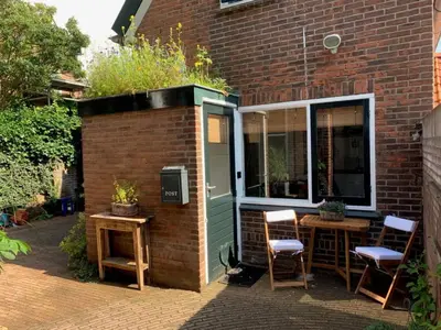 a patio with a table and chairs next to a building at Have a nice stay! - Pelican Dune near the beach in Noordwijk aan Zee
