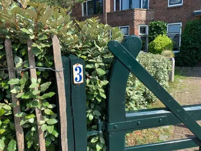 a green gate with the number three on it at Have a nice stay! - Pelican Dune near the beach in Noordwijk aan Zee