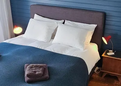 a bedroom with a large bed with a blue wall at Have a nice stay! - Strand Vakantiehuis Noordwijk in Noordwijk aan Zee