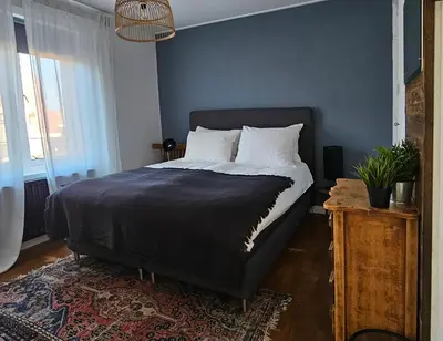a bedroom with a bed with a blue wall at Have a nice stay! - Strand Vakantiehuis Noordwijk in Noordwijk aan Zee