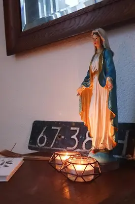 a statue of a woman with a candle on a clock at Have a nice stay! - Strand Vakantiehuis Noordwijk in Noordwijk aan Zee