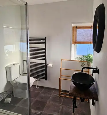 a bathroom with a toilet and a glass shower at Have a nice stay! - Strand Vakantiehuis Noordwijk in Noordwijk aan Zee