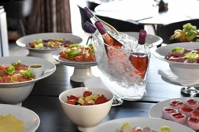a table with plates of food and a bottle of wine at Have a nice stay! - La Casita Alta Free Parking in Noordwijk aan Zee