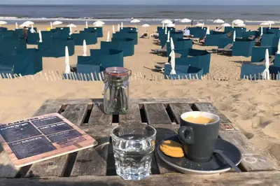 a table with a cup of coffee on the beach at Have a nice stay! - La Casita Alta Free Parking in Noordwijk aan Zee
