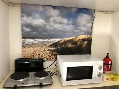 a microwave on a counter with a picture of a beach at Have a nice stay! - La Casita Alta Free Parking in Noordwijk aan Zee