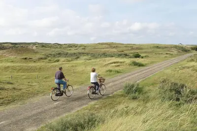 a man and woman riding bikes down a dirt road at Have a nice stay! - La Casita Alta Free Parking in Noordwijk aan Zee