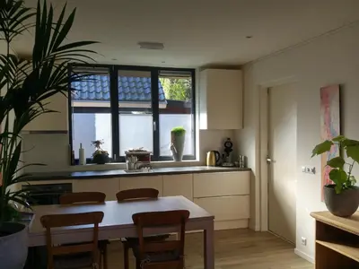 a kitchen with a table and chairs and a window at Appartementen Het Oude Atelier in Schoorl