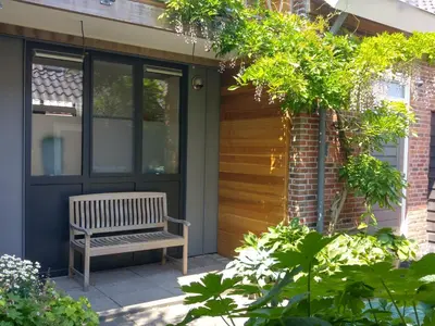 a bench sitting on the side of a house at Appartementen Het Oude Atelier in Schoorl