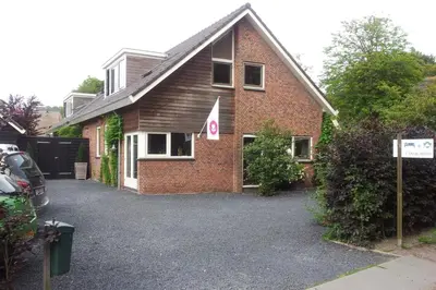a brick house with a parking lot in front of it at Appartementen Het Oude Atelier in Schoorl