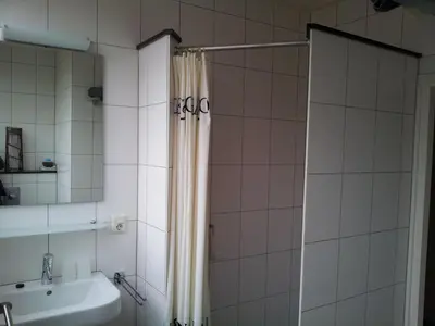 a bathroom with a shower curtain and a sink at Appartementen Het Oude Atelier in Schoorl