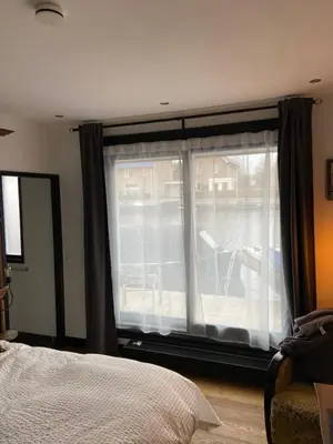 a bedroom with a window with a bed and a chair at Morpheus in Amsterdam