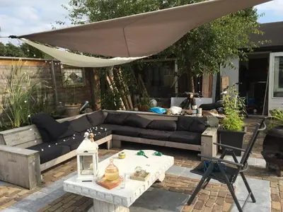 a patio with a couch and an umbrella at Morpheus in Amsterdam