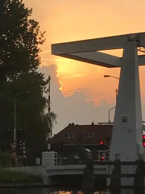 a sunset over a building and a bridge at Morpheus in Amsterdam