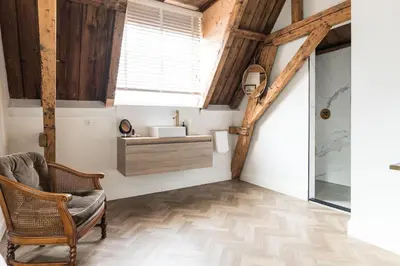 a living room with a chair and a window at Ysbrantsz Boutique Hotel in Hoorn