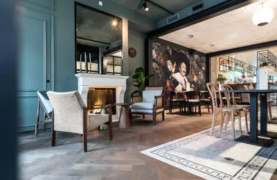 a living room with a fireplace and a table and chairs at Ysbrantsz Boutique Hotel in Hoorn