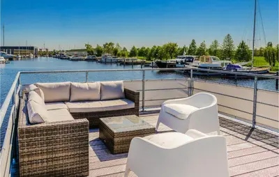 a deck with a couch and chairs on a boat at Cozy Ship In Aalsmeer With Wifi in Aalsmeer