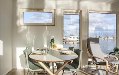 a dining room with a table and chairs and a boat at Cozy Ship In Aalsmeer With Wifi in Aalsmeer