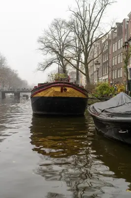 a yellow and black boat sitting in the water at 2 Houseboat Suites Amsterdam Prinsengracht in Amsterdam