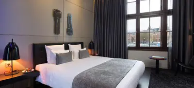 a hotel room with a large bed and a window at art'otel amsterdam, Powered by Radisson Hotels in Amsterdam