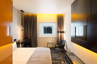 a hotel room with a bed and a chair at art'otel amsterdam, Powered by Radisson Hotels in Amsterdam