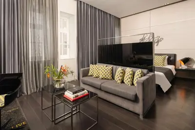a living room with a couch and a tv at art'otel amsterdam, Powered by Radisson Hotels in Amsterdam