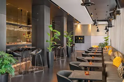 a restaurant with tables and chairs and plants at art'otel amsterdam, Powered by Radisson Hotels in Amsterdam