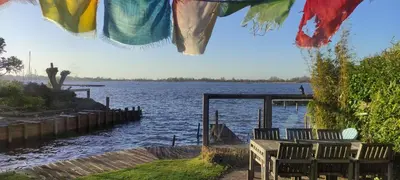 a group of chairs sitting next to a body of water at The Outpost Lakehouse- enjoy our house at Reeuwijkse Plassen - near Gouda in Reeuwijk