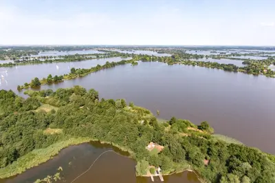 an aerial view of a river with trees and water at The Outpost Lakehouse- enjoy our house at Reeuwijkse Plassen - near Gouda in Reeuwijk