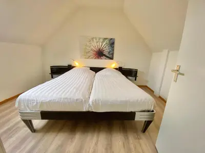a bedroom with a large white bed with lights on it at Zandvoort Central Apartment in Zandvoort