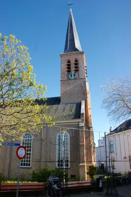 a church with a steeple with a clock on it at Zandvoort Central Apartment in Zandvoort