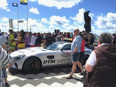 a group of people standing around a white car at Zandvoort Central Apartment in Zandvoort