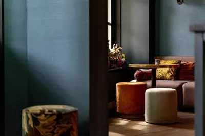 a living room with two suitcases and a couch at Hotel Mai Amsterdam in Amsterdam
