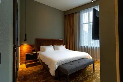 a bedroom with a bed and a large window at Hotel Mai Amsterdam in Amsterdam
