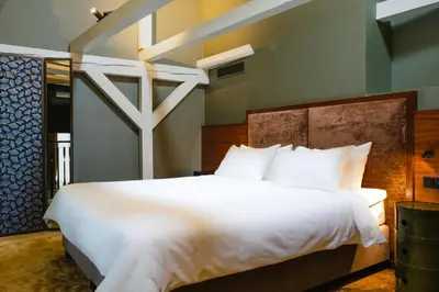 a bedroom with a large white bed with white pillows at Hotel Mai Amsterdam in Amsterdam