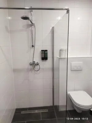 a bathroom with a glass shower with a toilet at House of Tulips in Hillegom