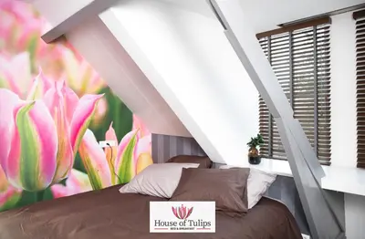 a bedroom with a bed with a flower mural at House of Tulips in Hillegom