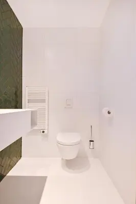 a white bathroom with a toilet and a sink at Chalet Santpoort-Zuid in Santpoort-Zuid