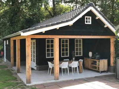 a large black shed with a table and chairs at Chalet Santpoort-Zuid in Santpoort-Zuid