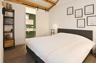 a bedroom with a white bed and a sink at Chalet Santpoort-Zuid in Santpoort-Zuid