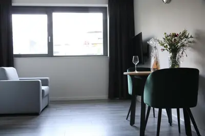 a living room with a desk with a vase of flowers at Greenstay in Amsterdam