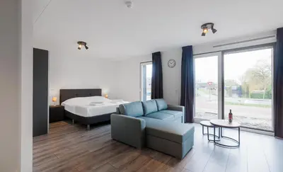 a living room with a bed and a couch and a table at Greenstay in Amsterdam