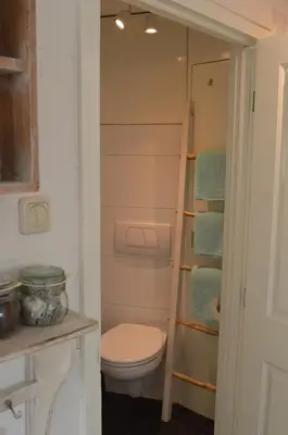 a bathroom with a toilet and a ladder at Sea in Egmond aan Zee