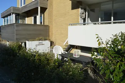 a bench sitting in front of a house at Sea in Egmond aan Zee