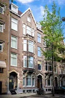an apartment building with a tree in front of it at De Ware Jacob Boutique Hotel in Amsterdam