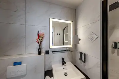 a white bathroom with a sink and a mirror at De Ware Jacob Boutique Hotel in Amsterdam