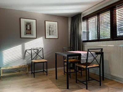 a dining room with a table and four chairs at In The Heart of Zandvoort in Zandvoort