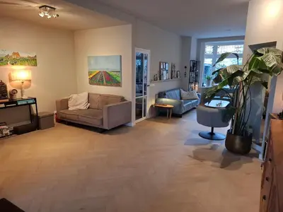 a living room with a couch and a plant at Zee-en-Zo Noordwijk in Noordwijk