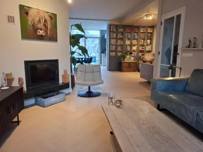 a living room with a couch and a fireplace at Zee-en-Zo Noordwijk in Noordwijk