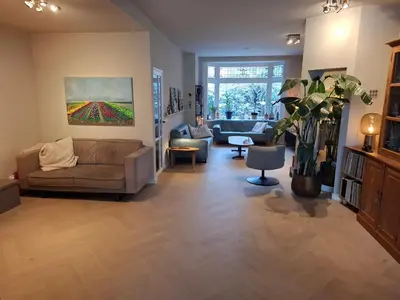 a living room with a couch and a painting on the wall at Zee-en-Zo Noordwijk in Noordwijk
