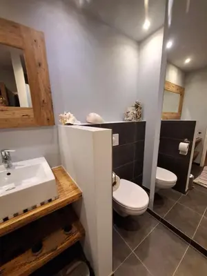 a bathroom with a white toilet and a sink at Zee-en-Zo Noordwijk in Noordwijk